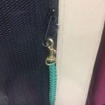 Kelly Green Zipper Pull with 3/8" brass clip, clipping two zippers closed